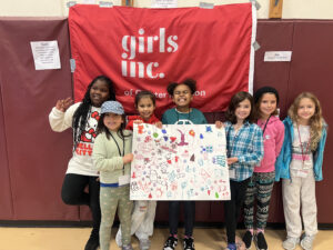 picture of girls holding a Girls Inc banner