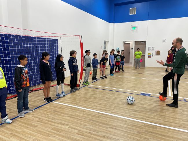picture of youth playing soccer in a gym