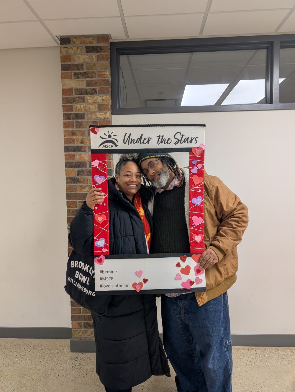 couple holding a themed picture frame outside of the MMSD Planetarium