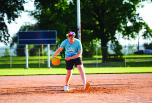 a man throwing a kickball on a field.
