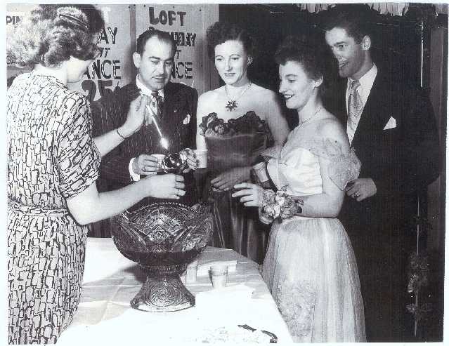 picture of people at a party posed around a punch bowl